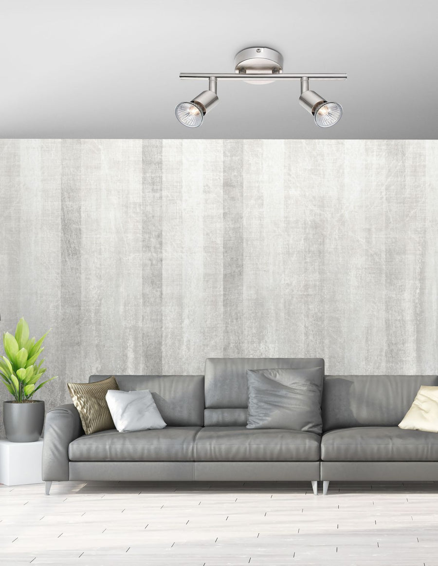 Plafonnier monté au plafond au-dessus d'un canapé gris, dans un salon.