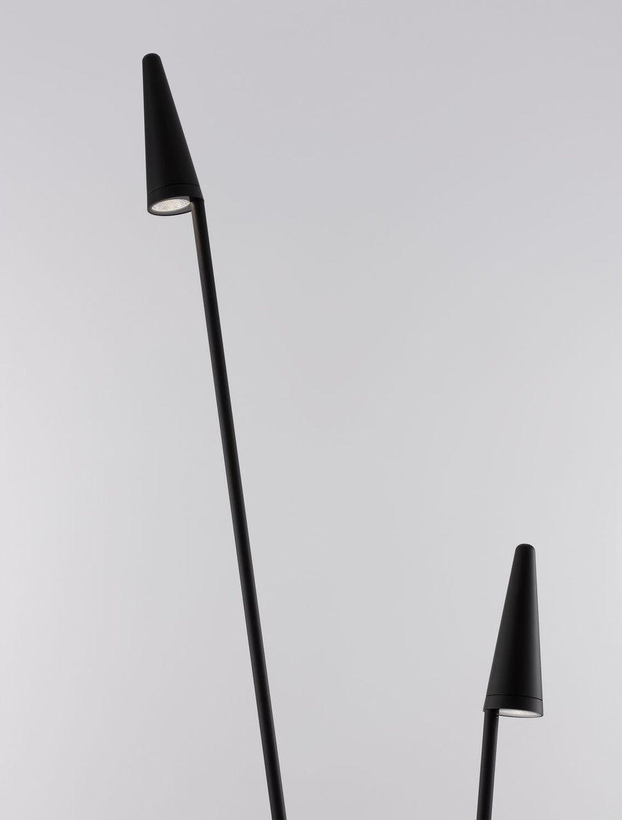 Détail rapproché d'une tête conique noire avec la source lumineuse visible.