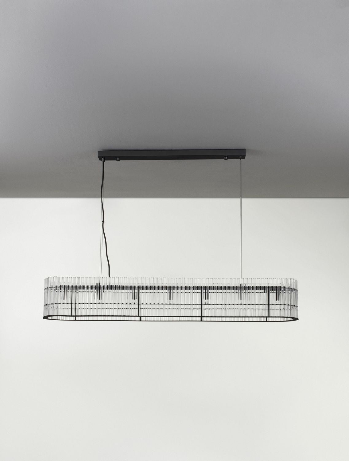 Vue frontale du luminaire éteint suspendu, tiges de verre alignées régulièrement