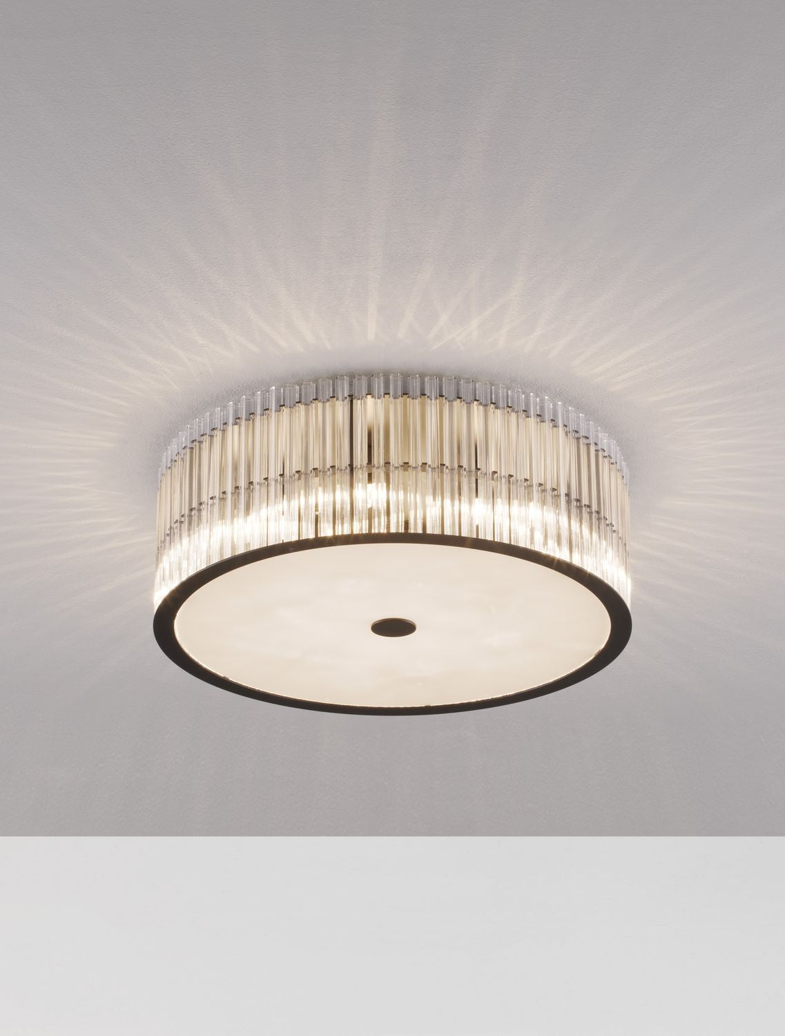 Luminaire allumé projetant des rayons lumineux en étoile sur le plafond.