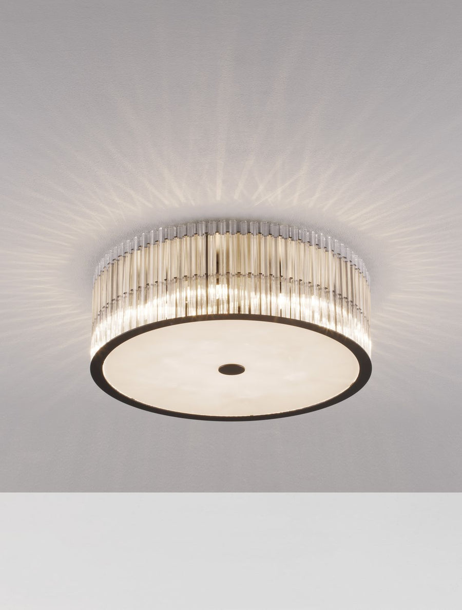 Luminaire allumé projetant des rayons lumineux en étoile sur le plafond.