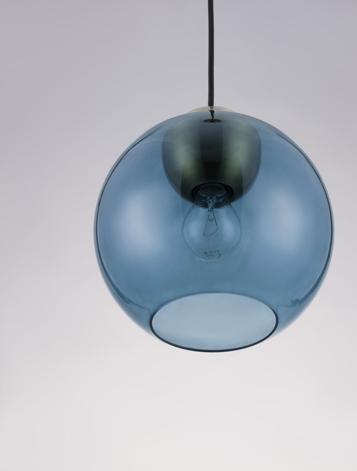 Gros plan sur la sphère de verre bleu et l'ampoule à filament visible