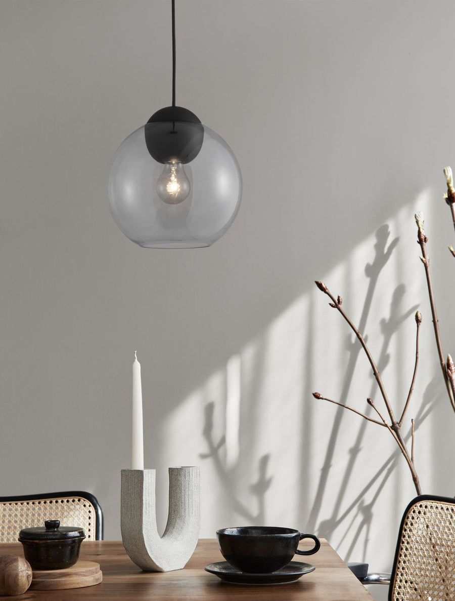 Suspension en verre fumé suspendue au-dessus d'une table en bois dressée