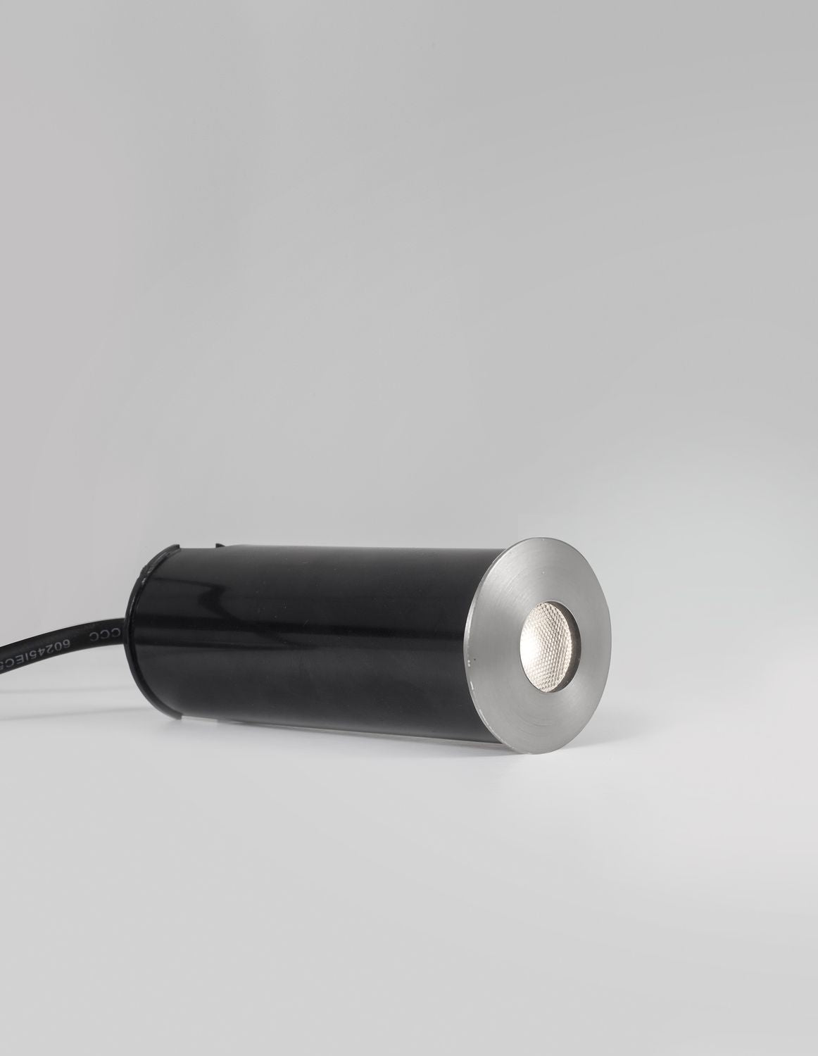 Luminaire cylindrique noir couché, collerette nickel et verre strié, câble visible