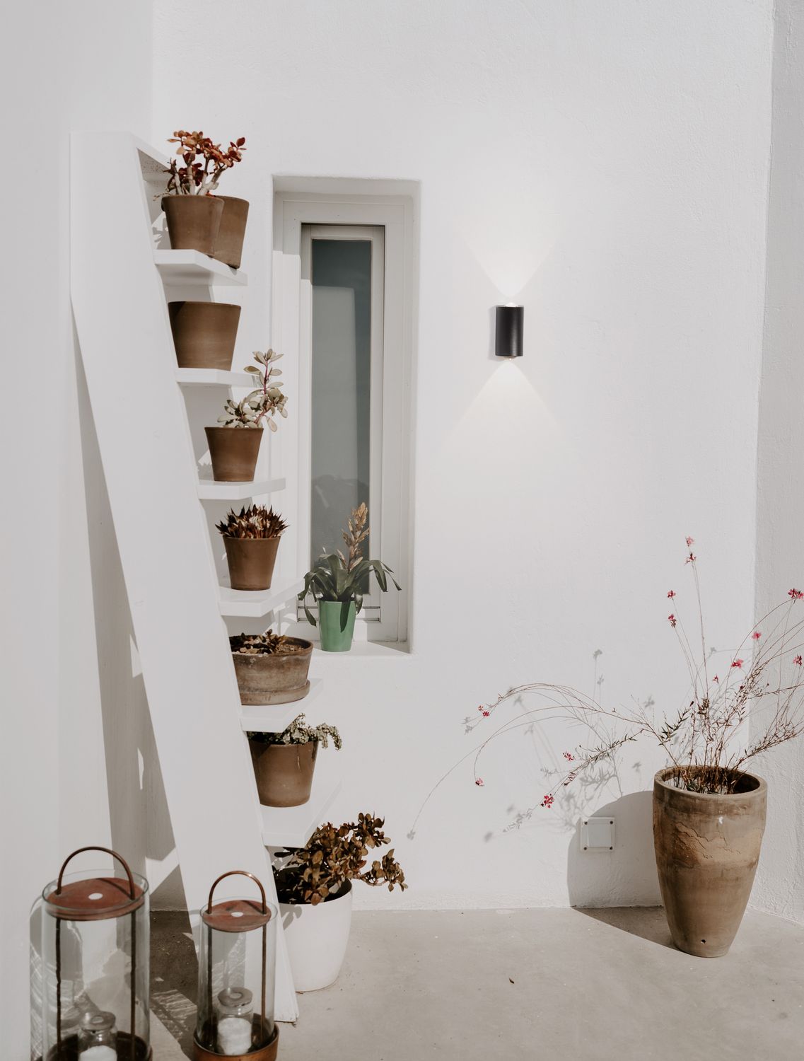 Applique noire allumée sur mur blanc, éclairant vers le haut et le bas