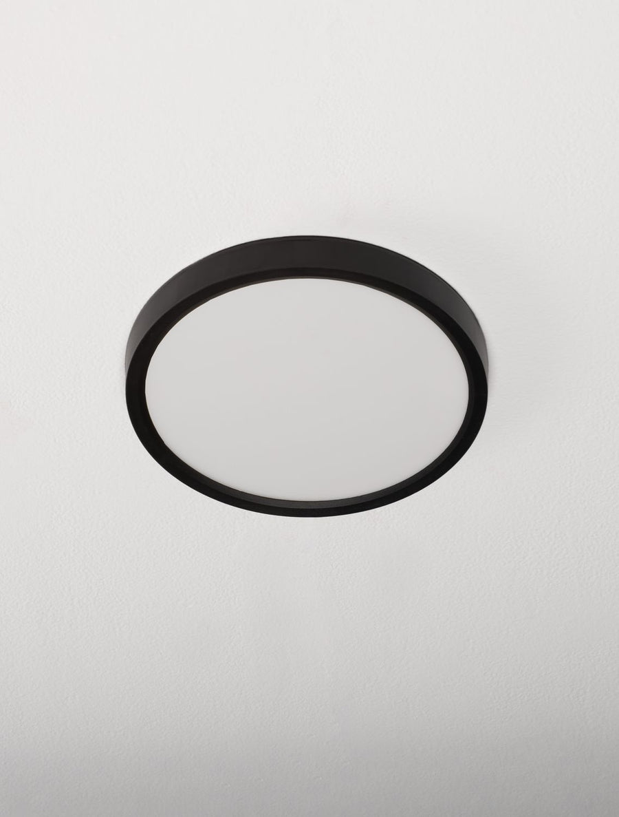 Plafonnier rond fixé au plafond blanc, vue légèrement en contre-plongée