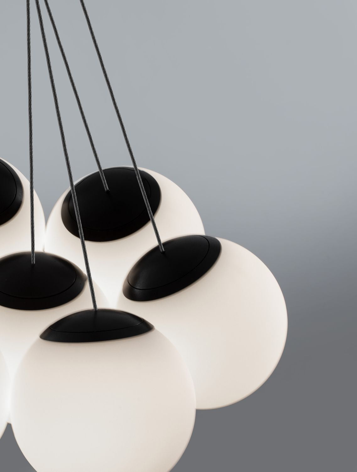 Gros plan sur les cabochons noirs et les câbles reliant chaque globe de verre