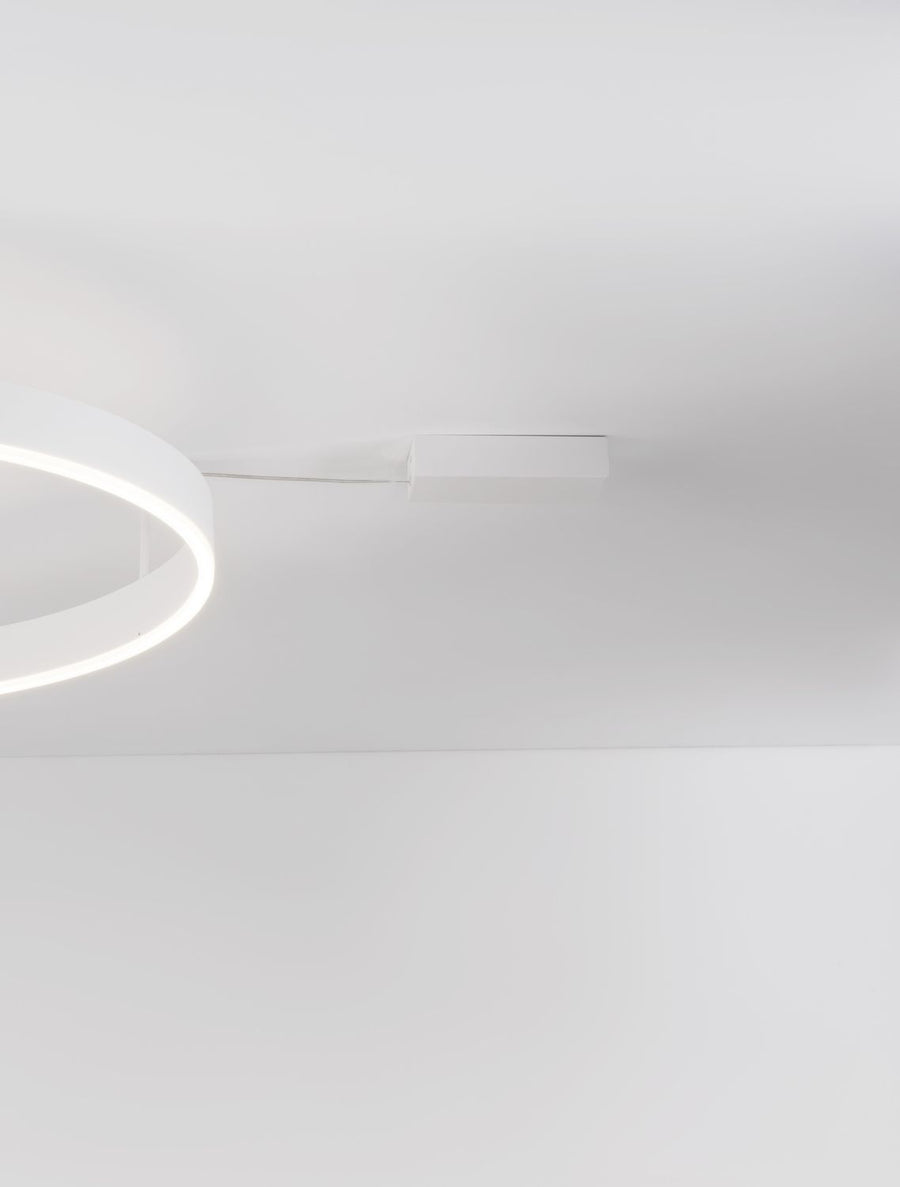 Détail du boîtier blanc fixé au plafond et du câble reliant la suspension.