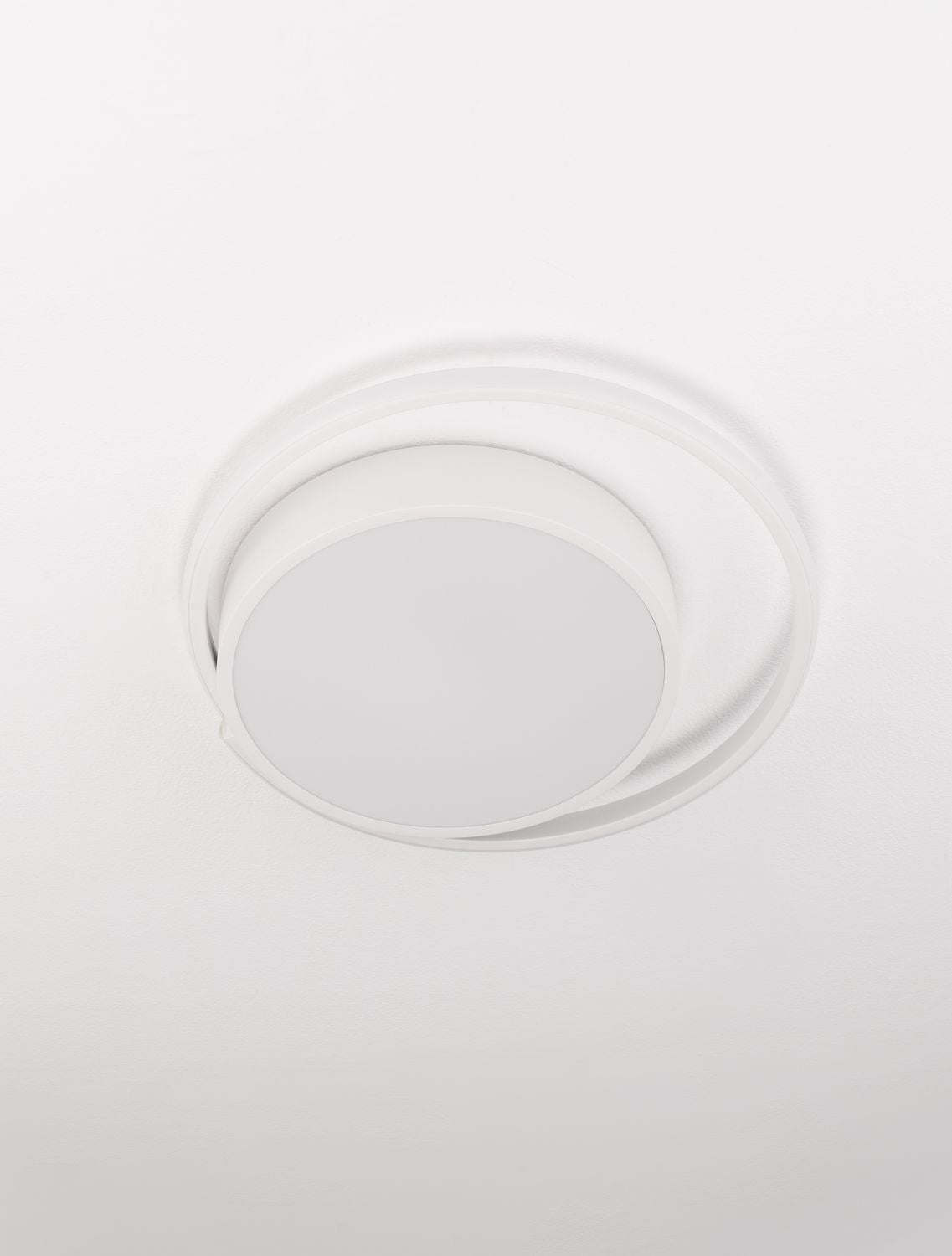 Vue rapprochée du plafonnier blanc fixé au plafond, éteint.