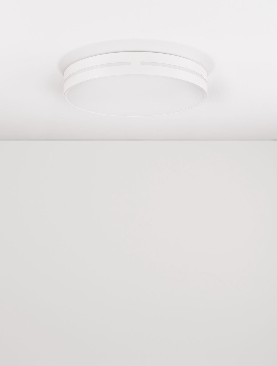 Luminaire installé au plafond, lumière douce diffusée vers le bas en ambiance