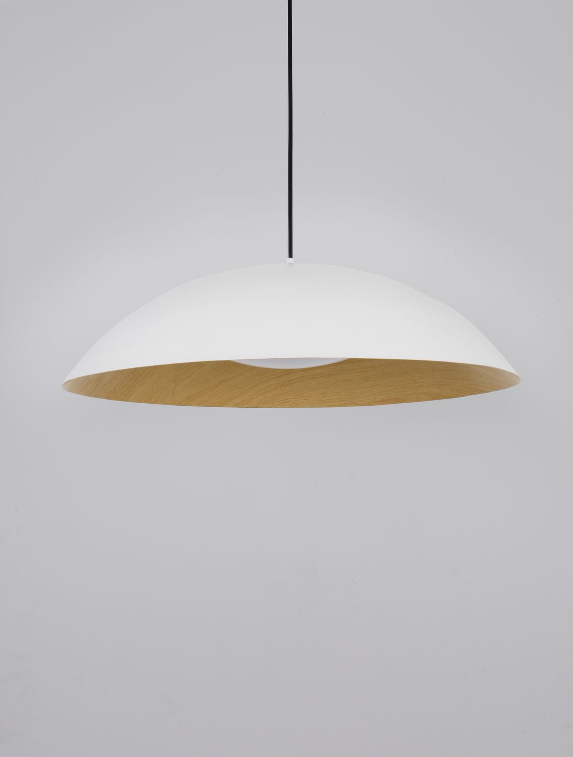 Vue rapprochée de la suspension blanche, abat-jour hémisphérique et finition intérieure en bois naturel.