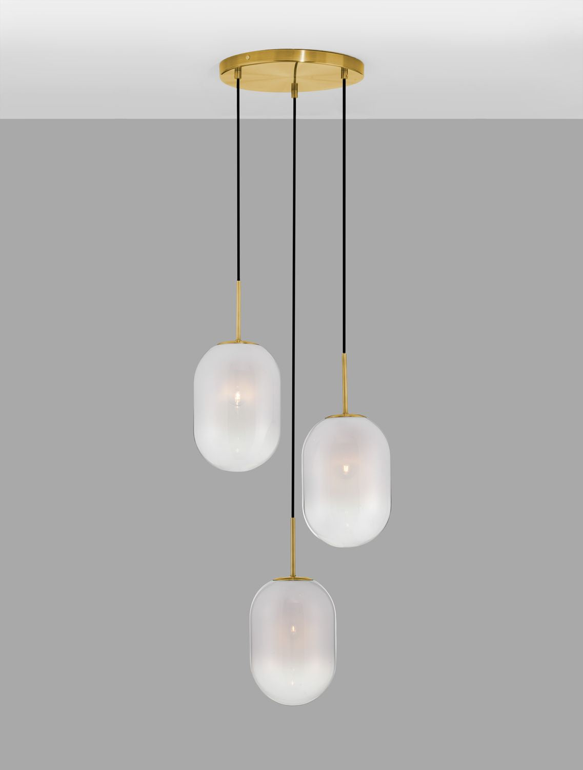 Suspension allumée sur fond gris, diffusant une lumière chaude à travers le verre dépoli