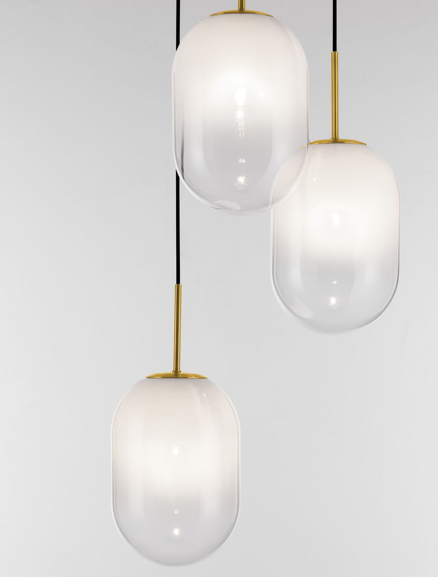 Détail rapproché des trois globes en verre allumés, montrant transparence et lumière
