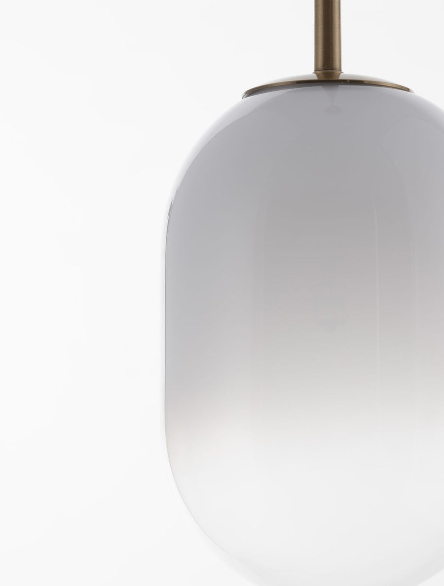 Détail du raccord entre la tige dorée et l'abat-jour en verre blanc.