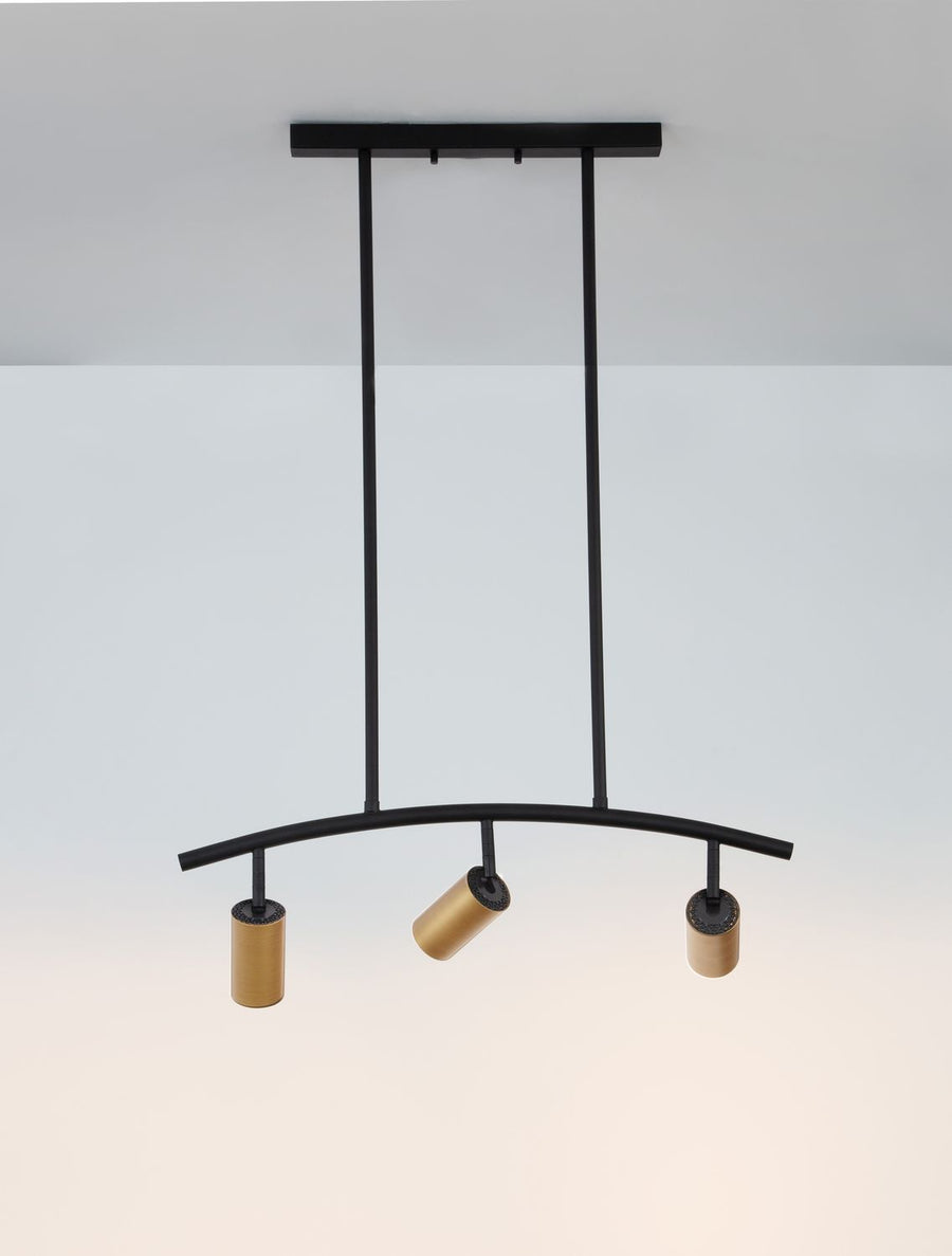 Vue rapprochée de la suspension noire et de ses projecteurs dorés orientables