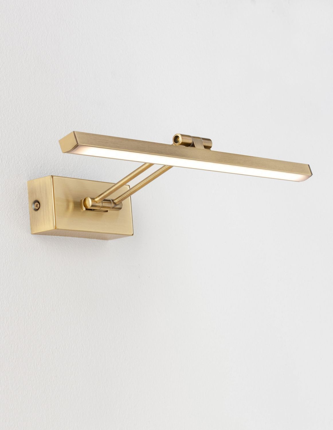Même applique allumée, diffusant une lumière chaude sur le mur blanc