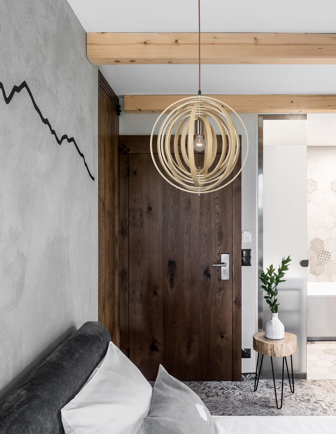 Suspension en bois cintré installée au-dessus d'une porte en bois foncé
