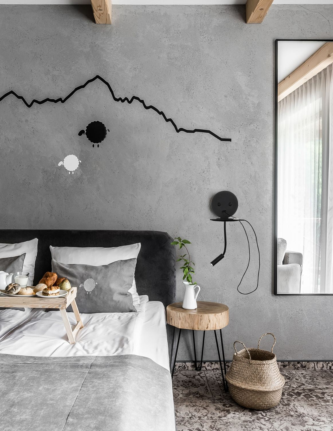 Applique murale noire fixée au mur au-dessus d'une table de chevet en bois