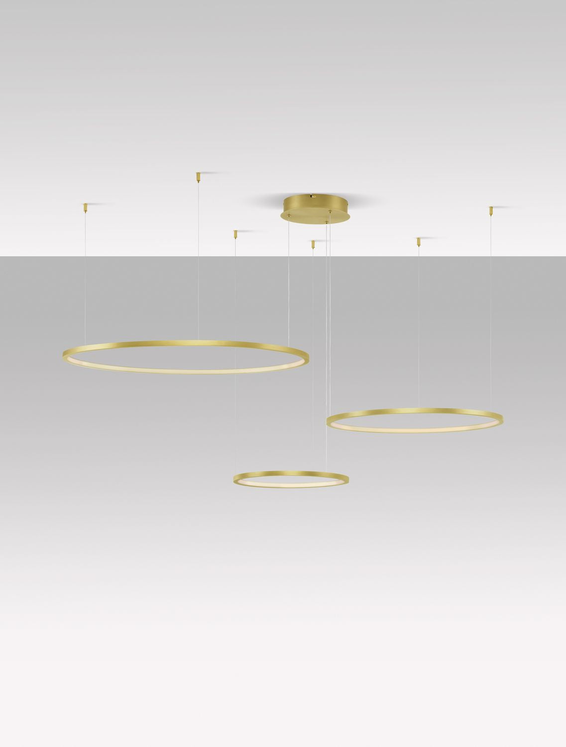Vue d'ensemble du luminaire suspendu avec trois anneaux dorés à différentes hauteurs