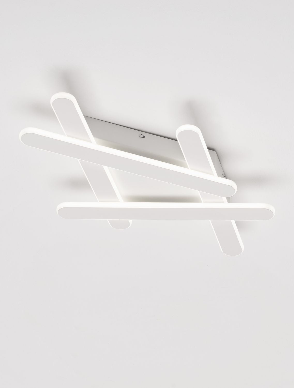 Plafonnier blanc allumé fixé au plafond, vu en angle
