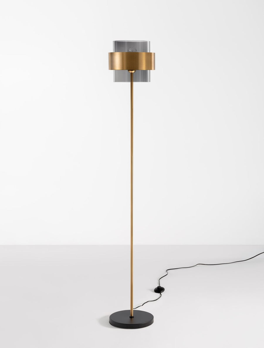 Lampadaire entier avec câble noir apparent posé sur un sol blanc