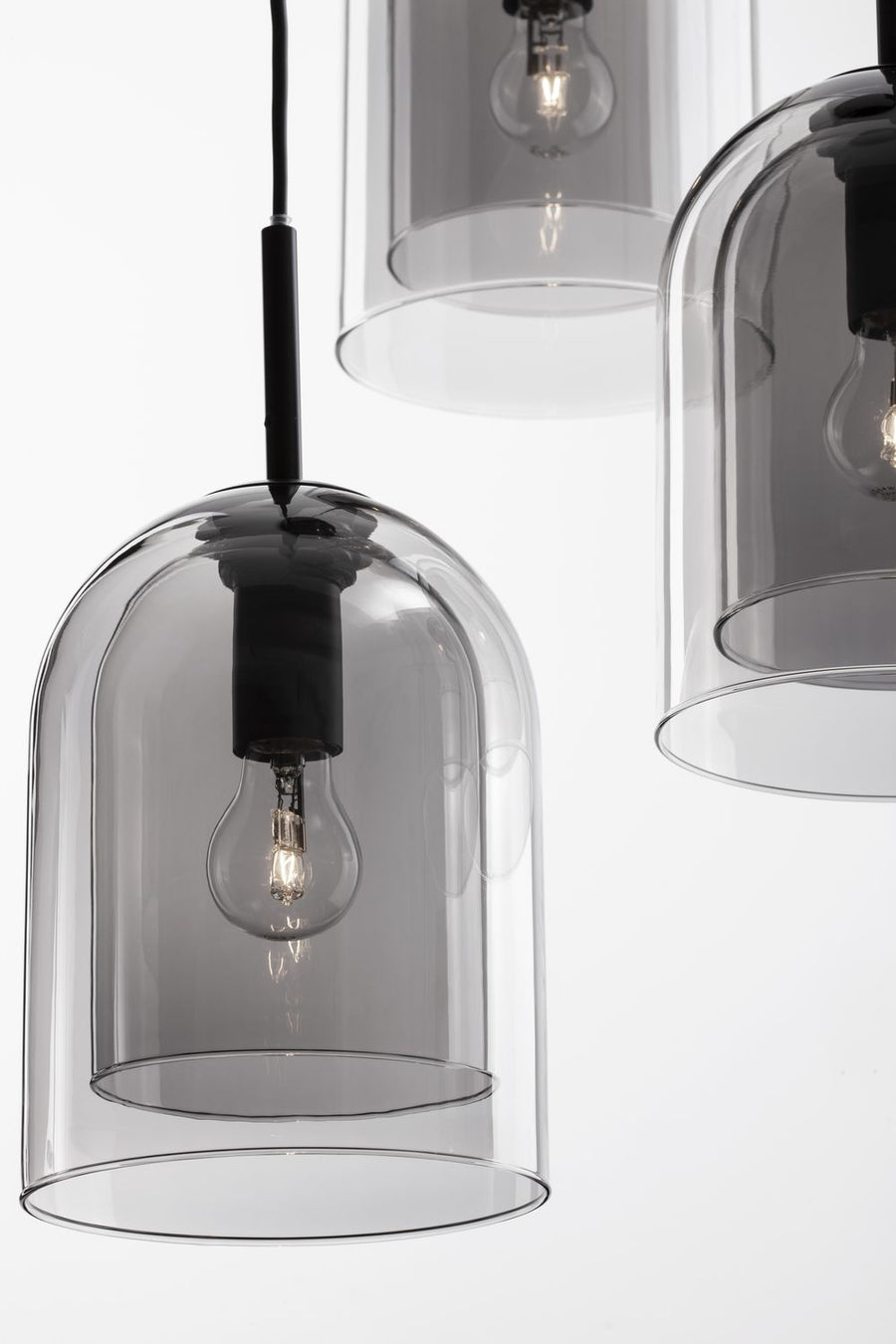 Gros plan sur un abat-jour en verre transparent fumé et son ampoule vissée