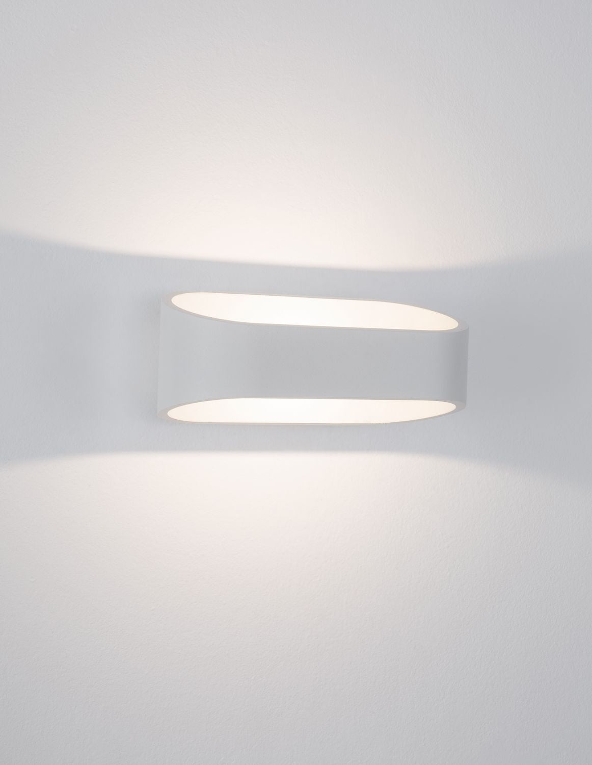 Diffuseur allumé projetant deux halos de lumière douce sur le mur blanc