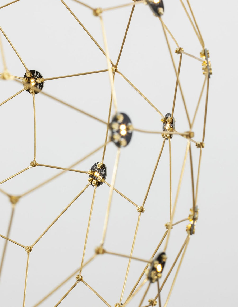 Détail macro des modules LED noirs et tiges dorées assemblées en étoile