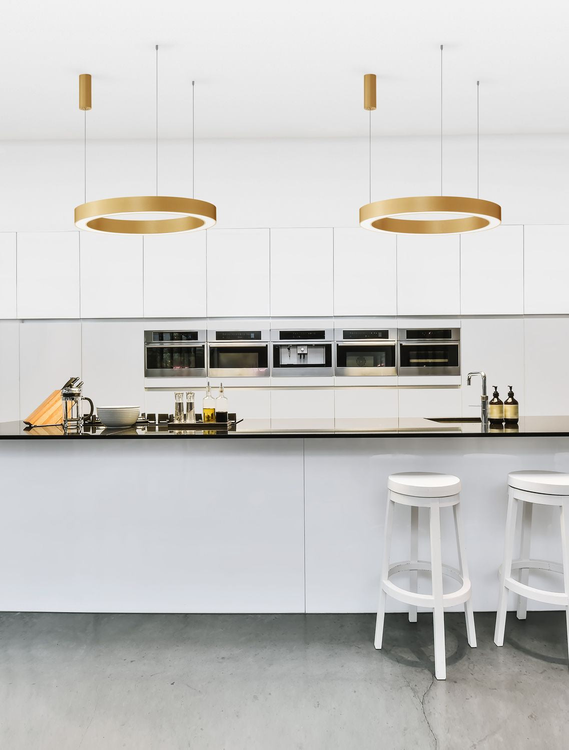 Suspension dorée au-dessus d'un îlot de cuisine blanc, mise en ambiance réelle