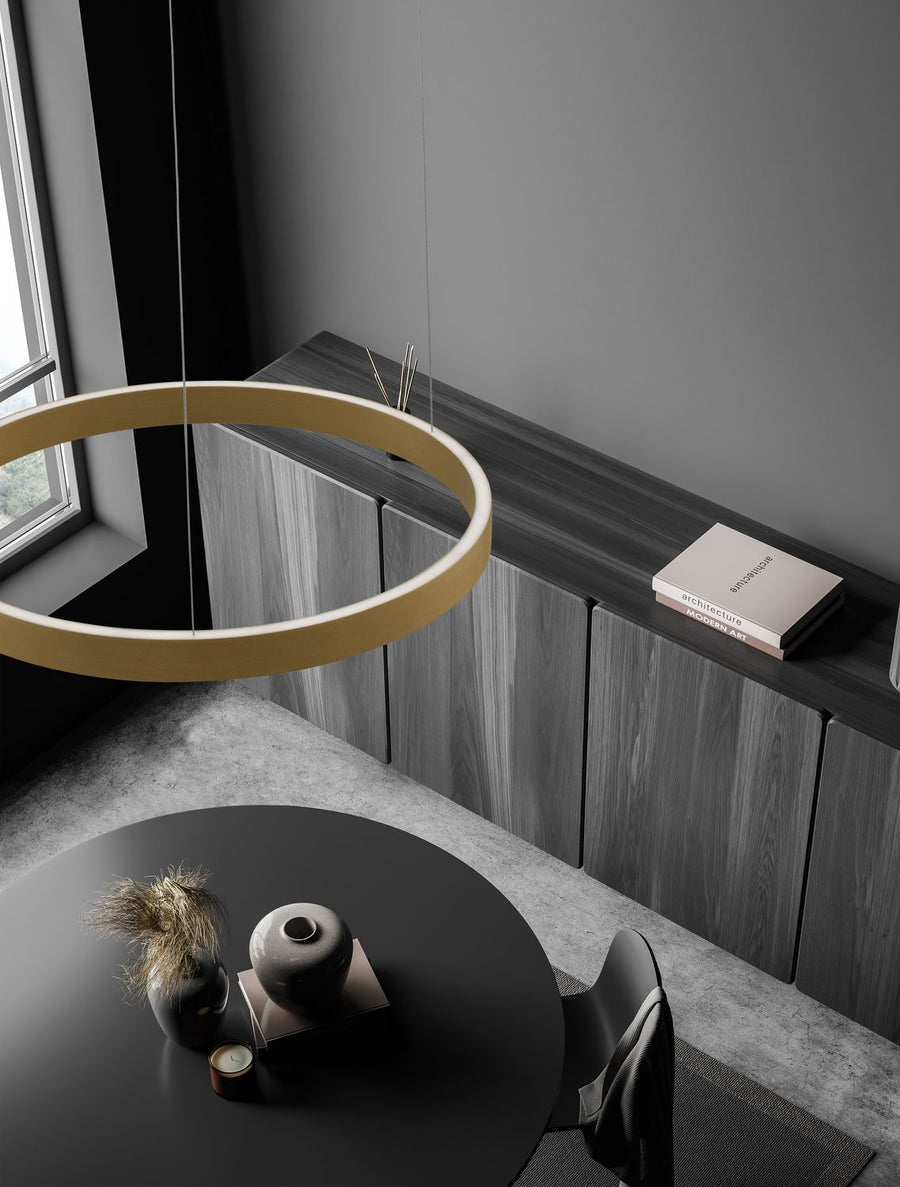 Suspension anneau doré installée au-dessus d'une table ronde dans une pièce sombre