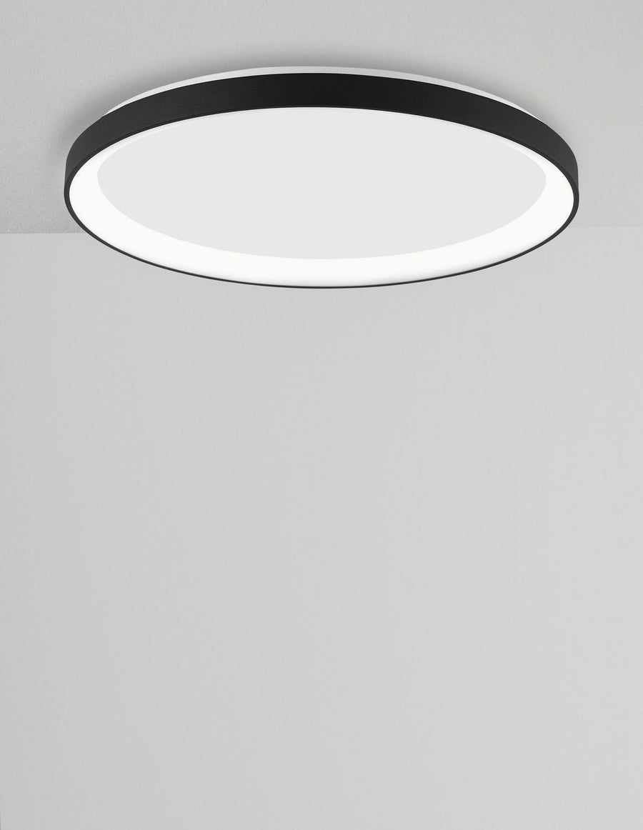 Luminaire rond vu de dessous, cerclage noir et diffuseur opalin blanc