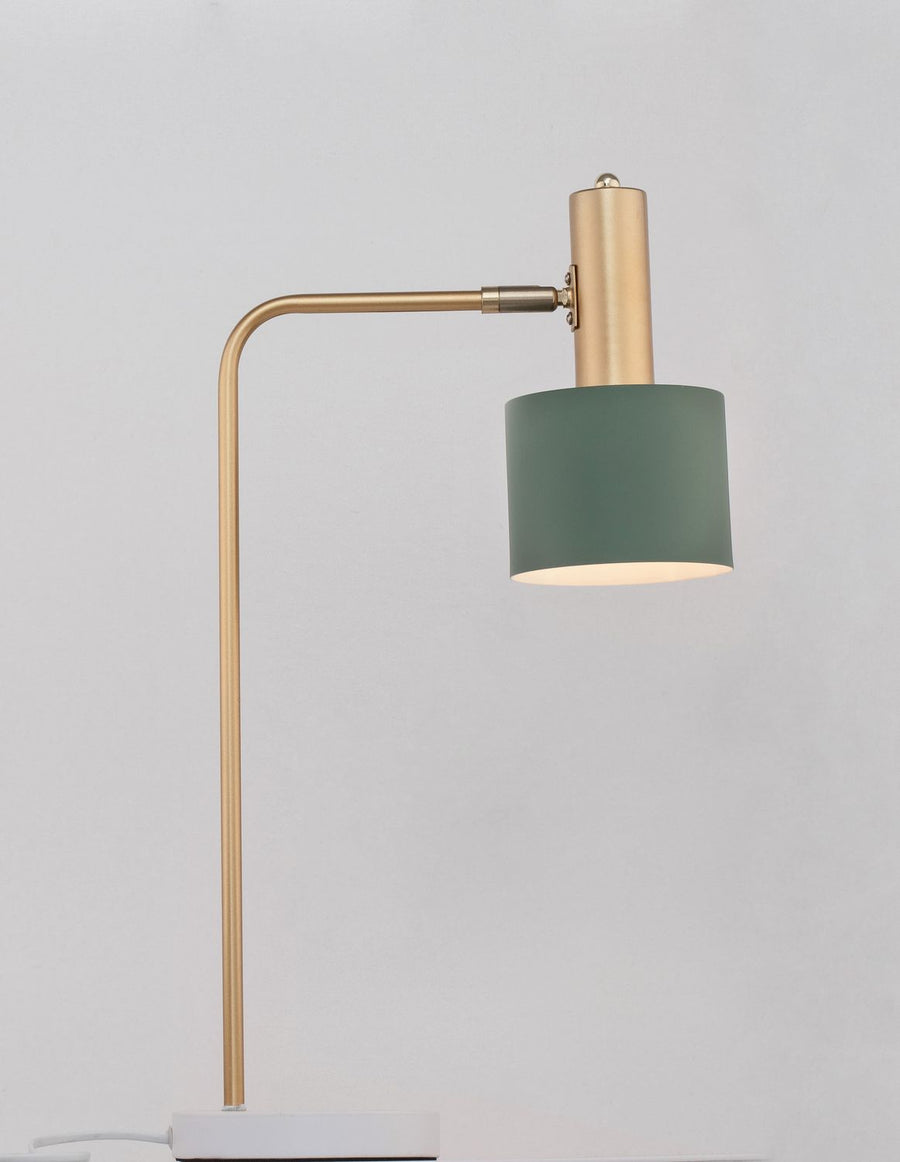 Lampe à poser allumée de profil, abat-jour vert diffusant une lumière chaude.