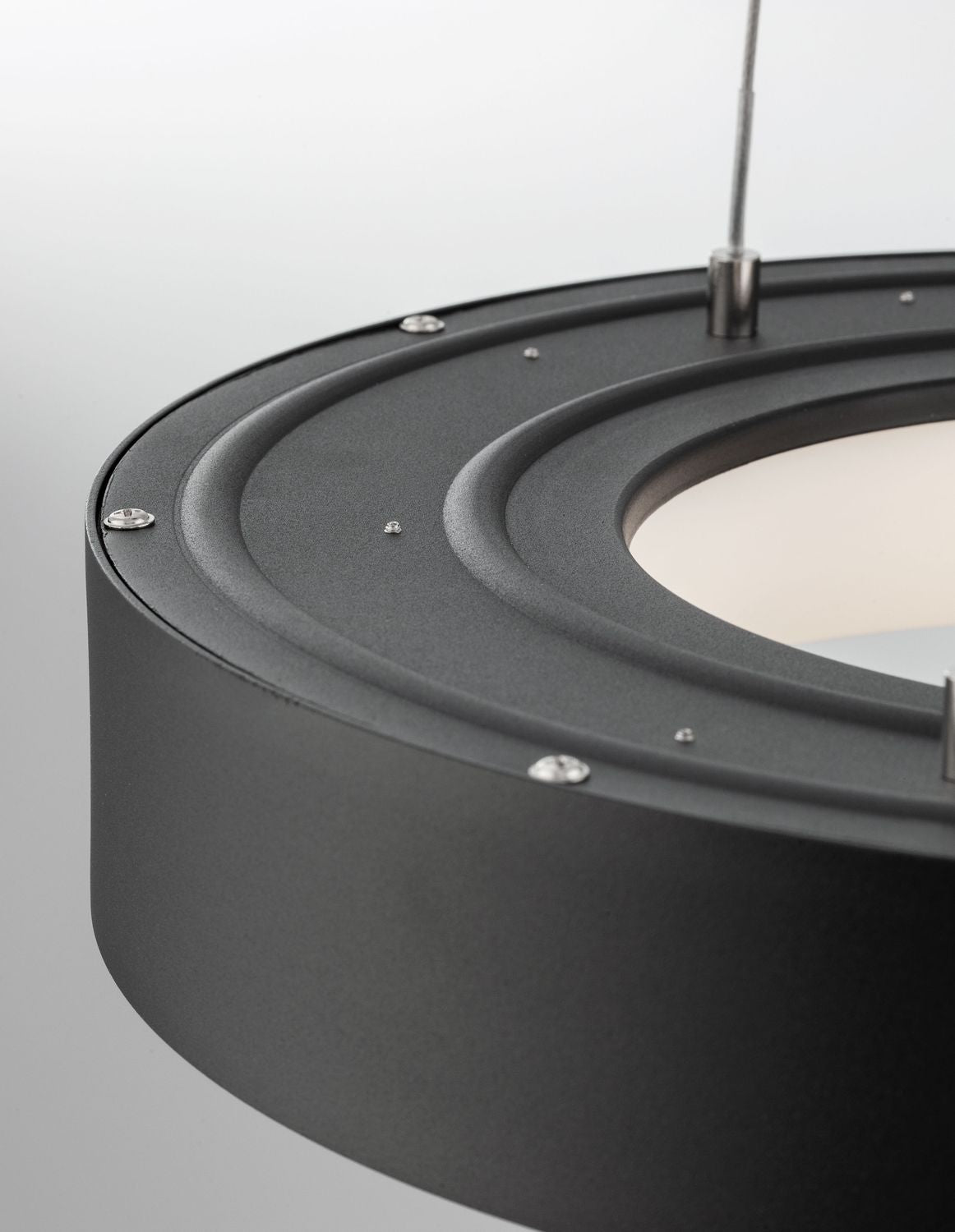 Détail du dessus du luminaire noir avec vis et fixations apparentes