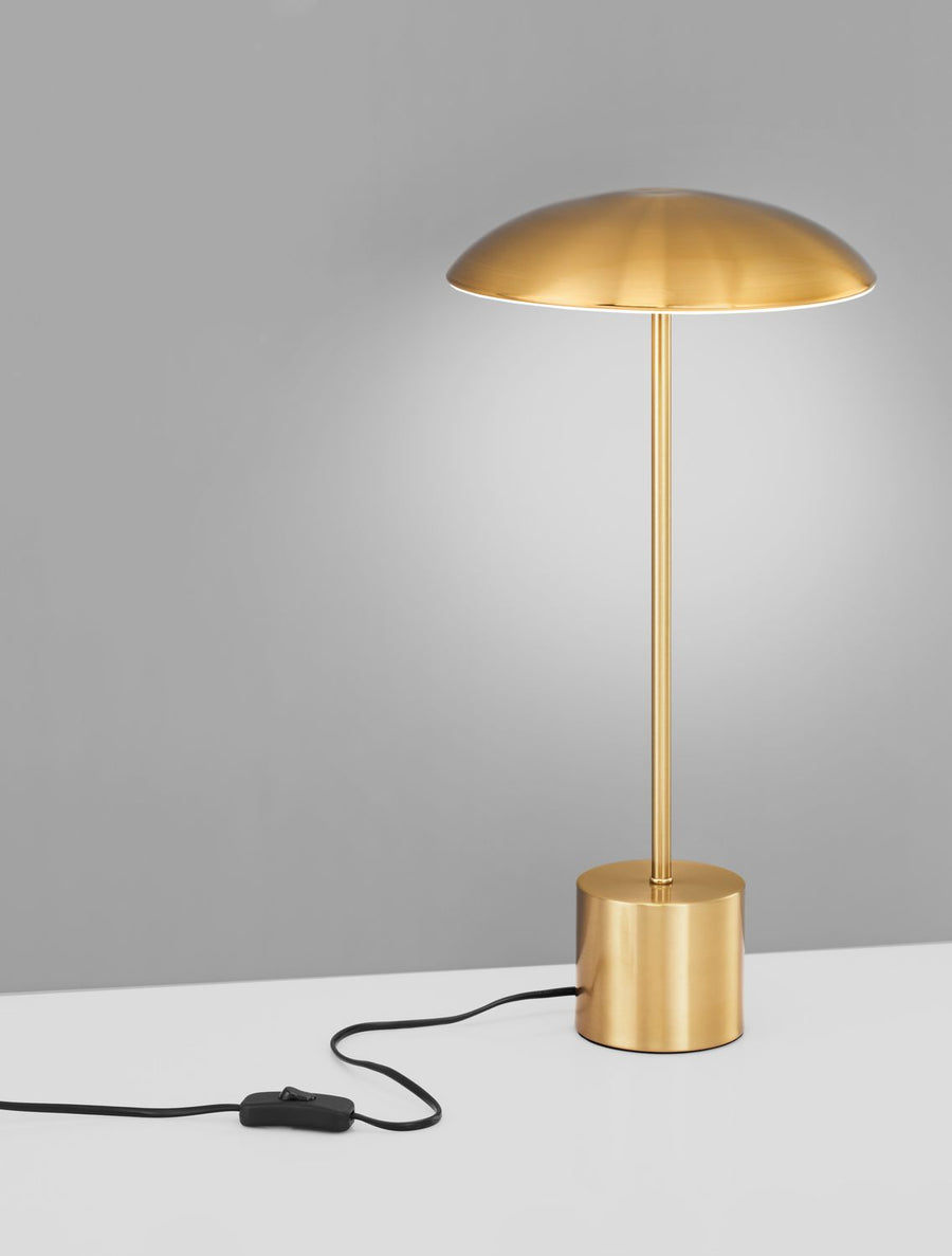 Lampe dorée sur fond gris, mettant en valeur le câble et l'interrupteur.