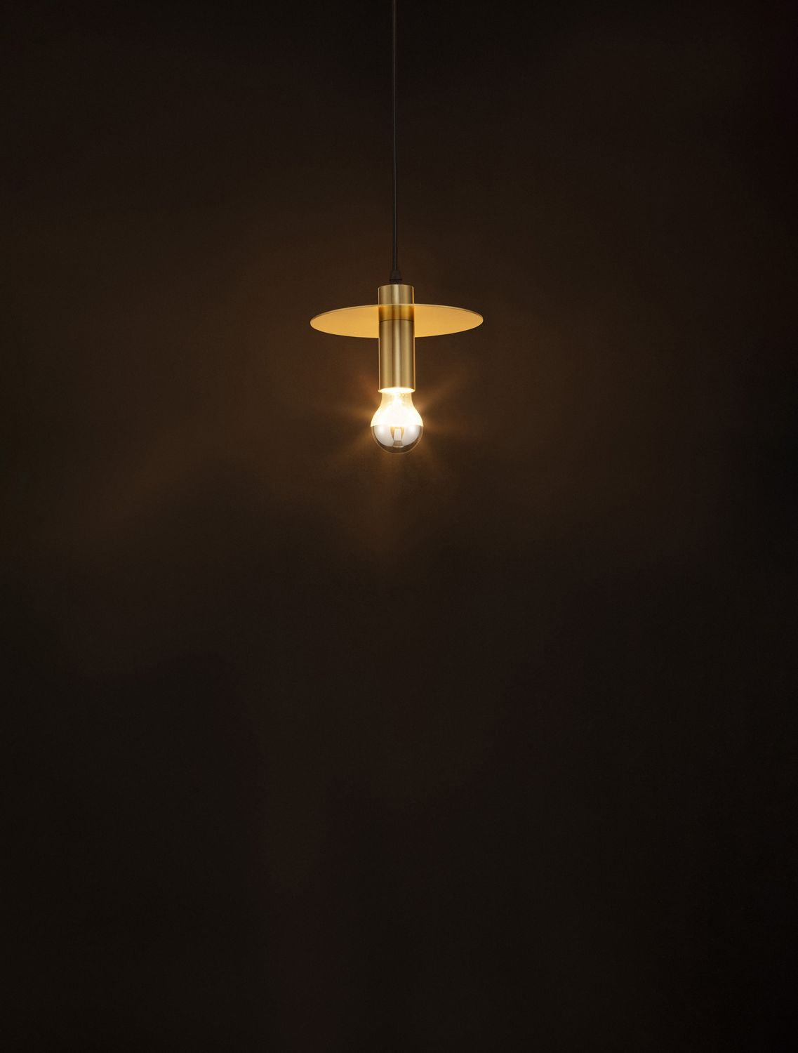 Mise en ambiance nocturne de la suspension dorée allumée sur fond sombre