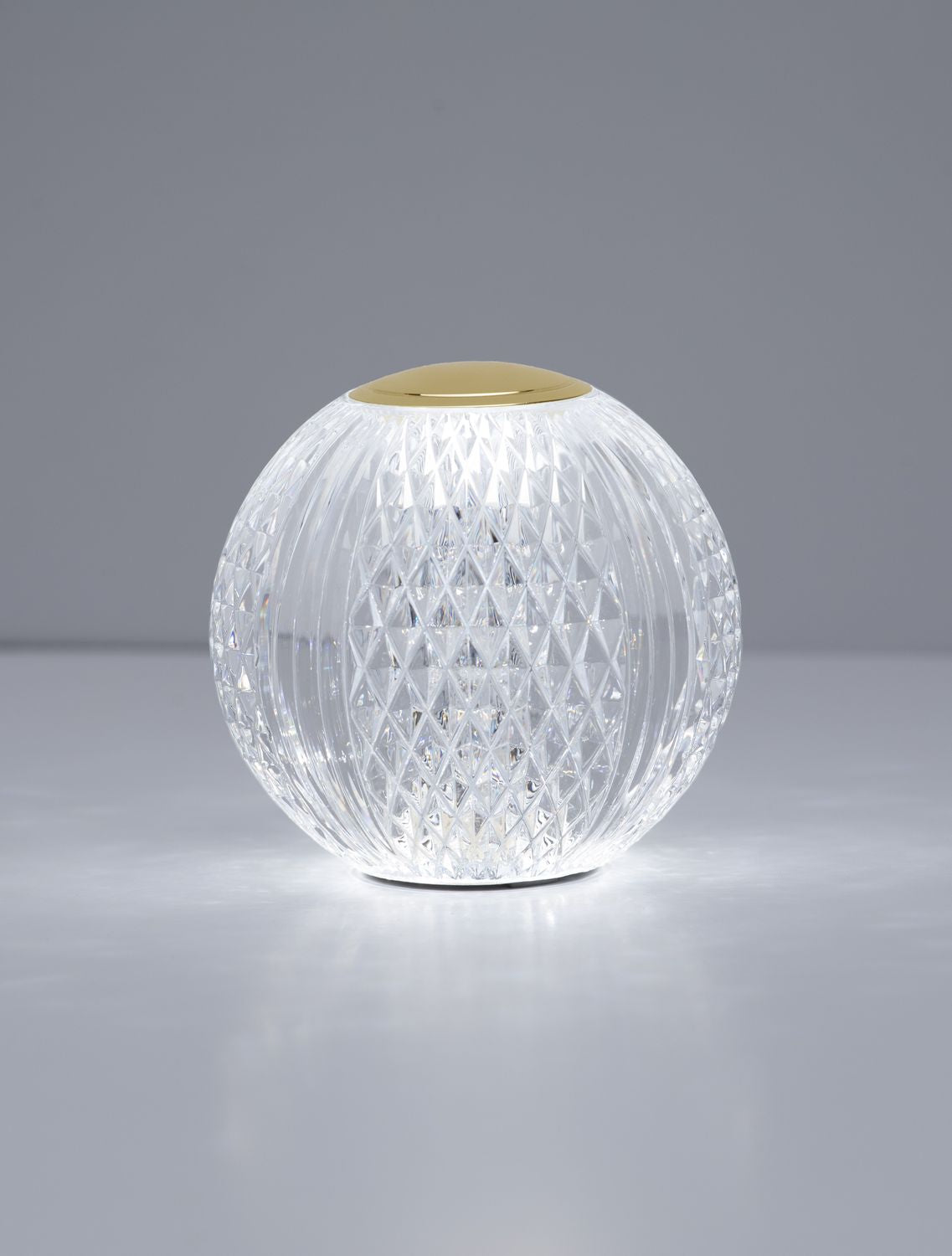 Mise en ambiance sur surface réfléchissante, lampe allumée diffusant une lumière chaleureuse.