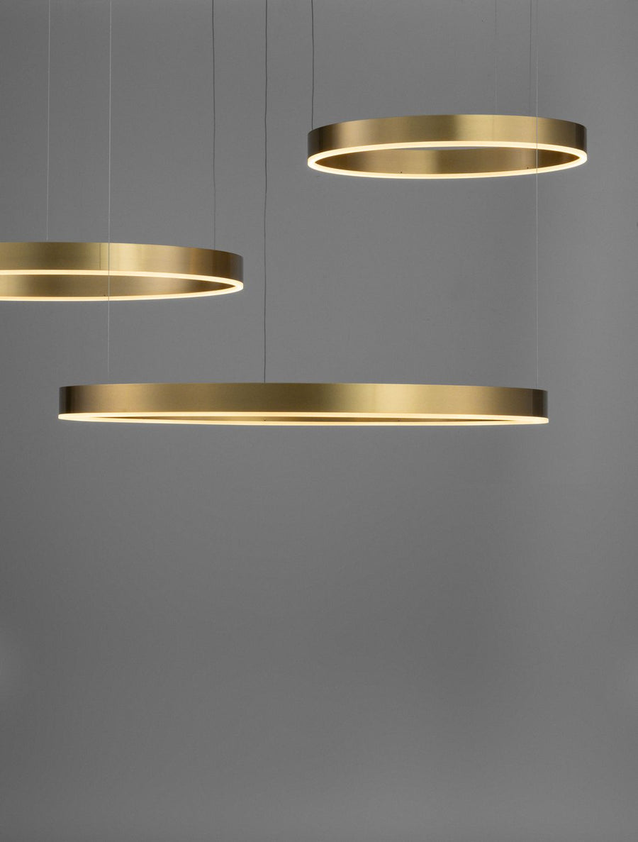 Détail rapproché des anneaux dorés éclairés par LED sur fond gris