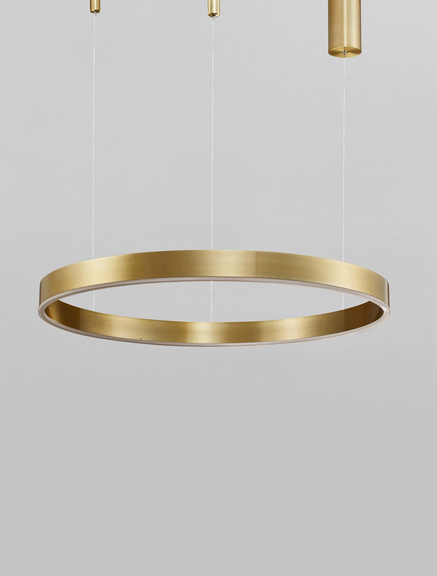 Détail du bandeau lumineux blanc sous l'anneau en laiton brossé.
