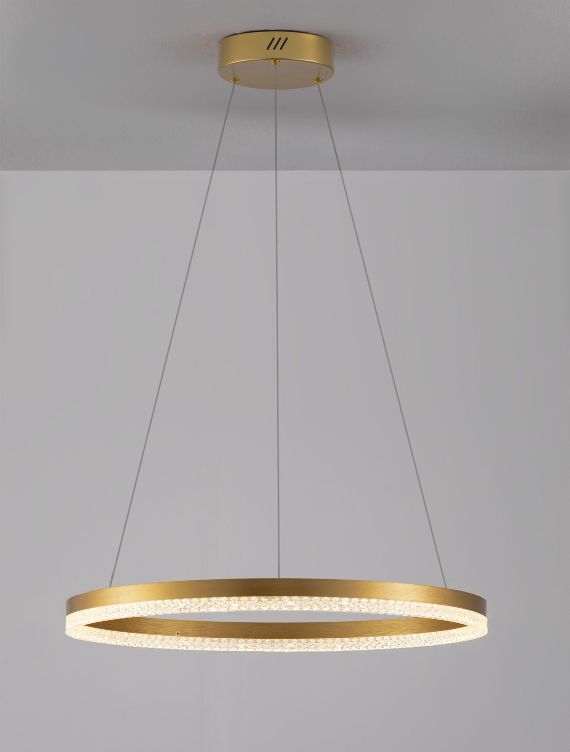 Suspension lumineuse ronde en laiton avec diffuseur texturé, éclairée et fixée au plafond.
