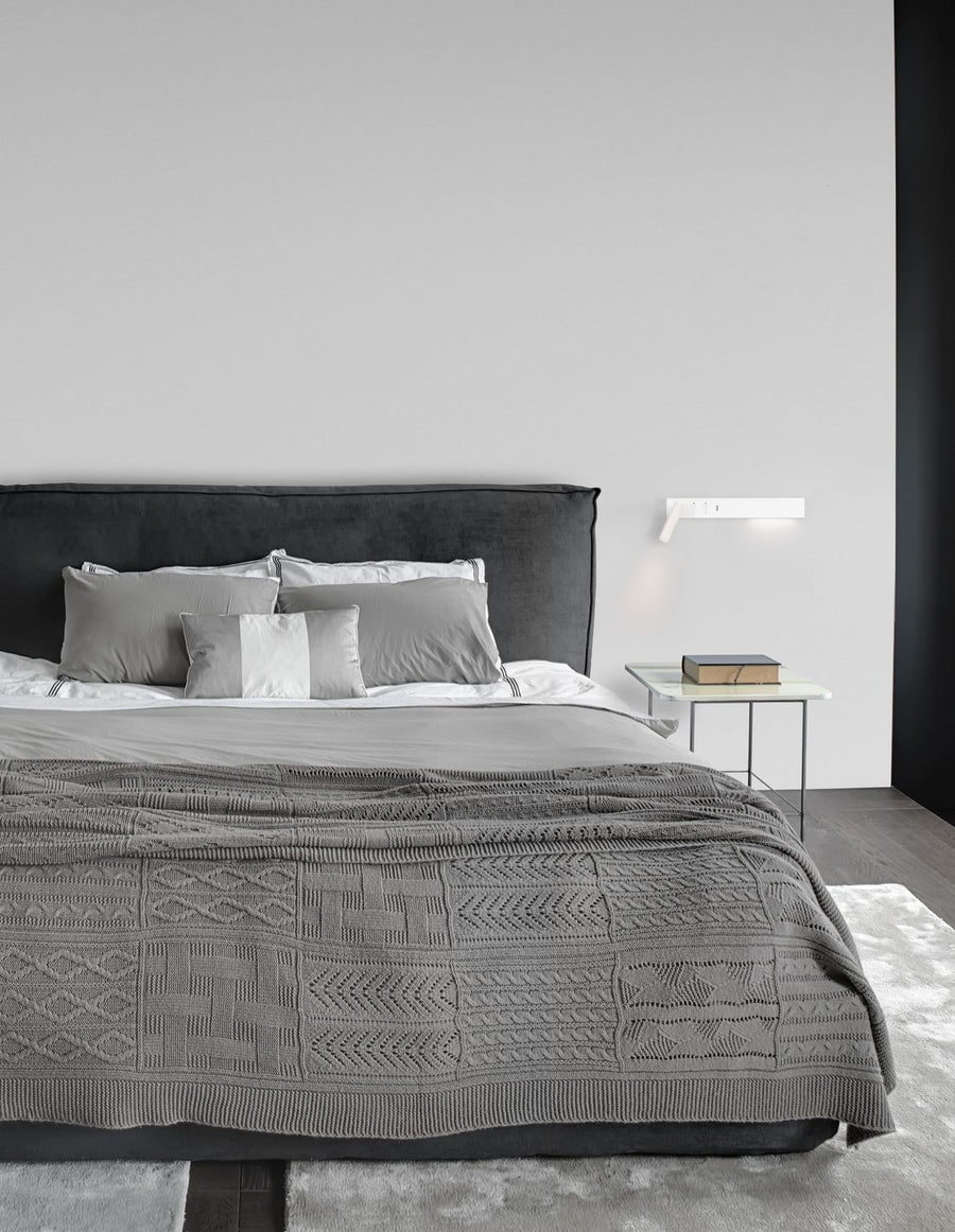 Applique murale blanche éclairant la tête de lit dans une chambre contemporaine