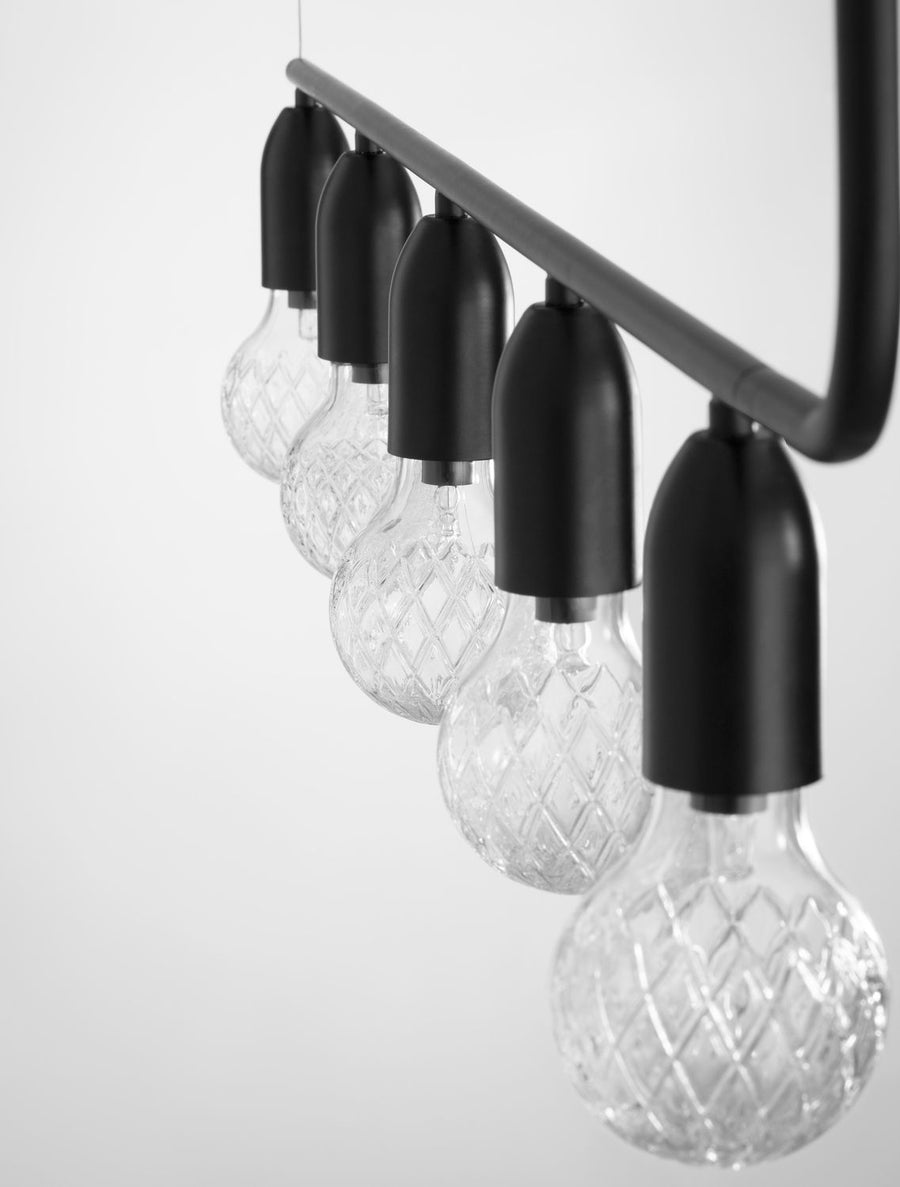 Gros plan latéral sur les ampoules texturées et le support métallique