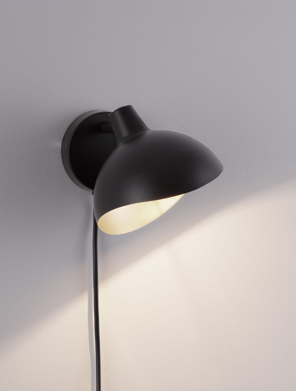 Détail de l applique allumée projetant une lumière chaude sur le mur