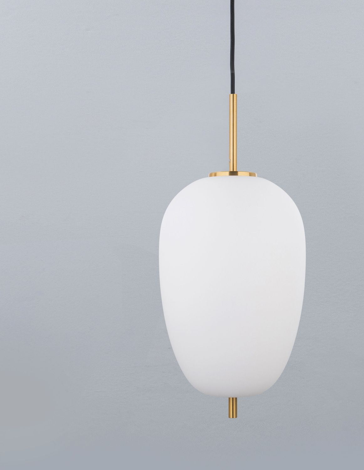 Vue de face d'une suspension au globe de verre blanc et tige en laiton