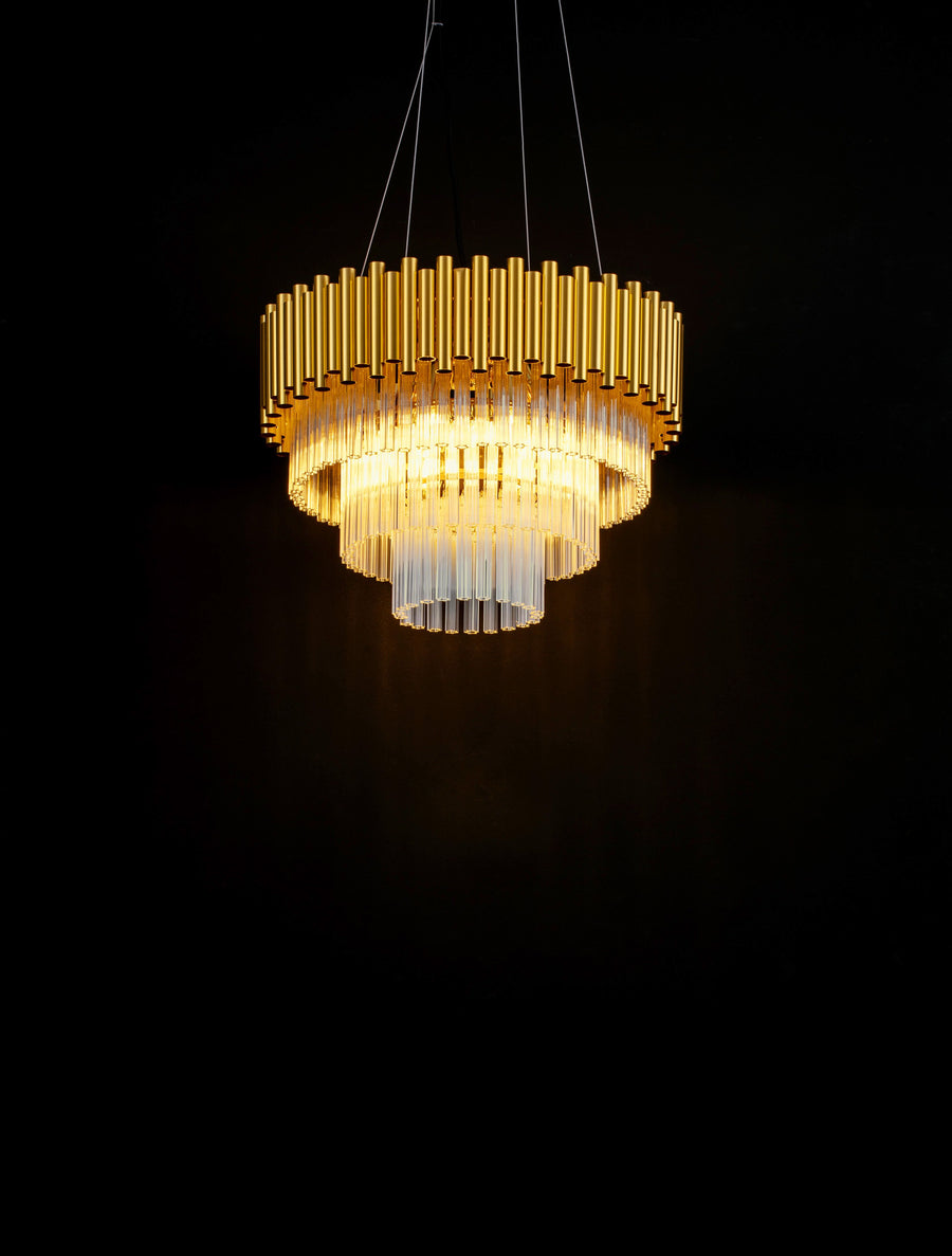 Luminaire allumé dans l'obscurité, mettant en valeur le cristal et la dorure.
