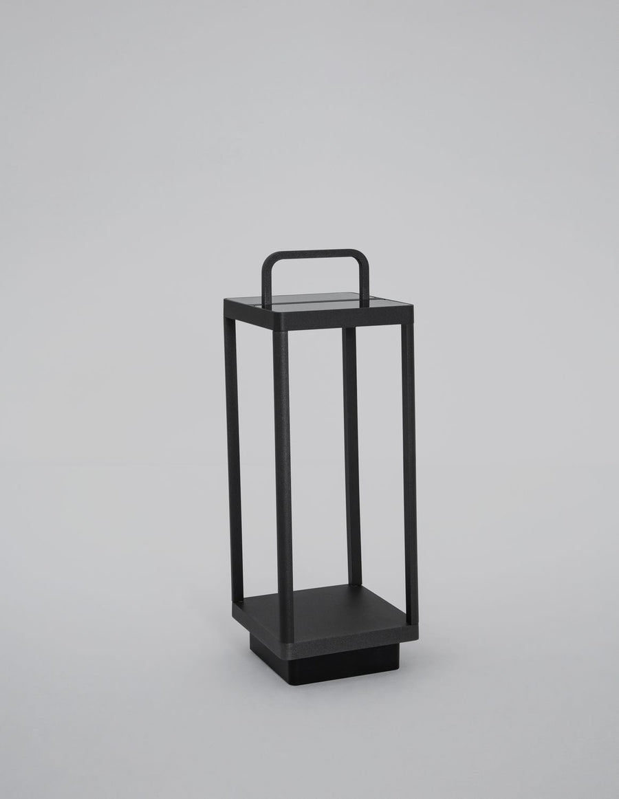 Borne extérieure noire présentée de trois quarts sur fond neutre, cadre ouvert et base stable.