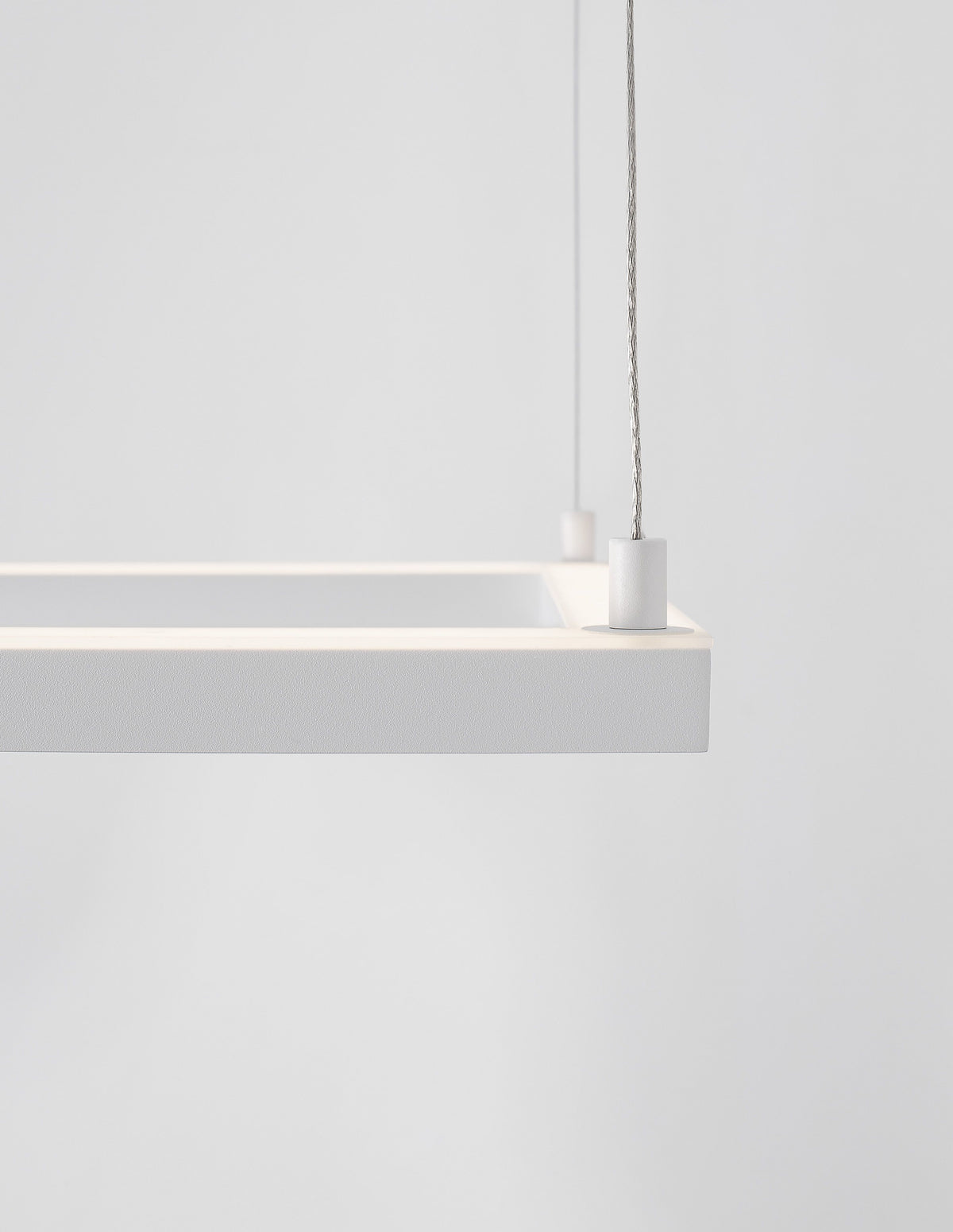 Détail du coin du cadre carré blanc, finition textile et câble de suspension