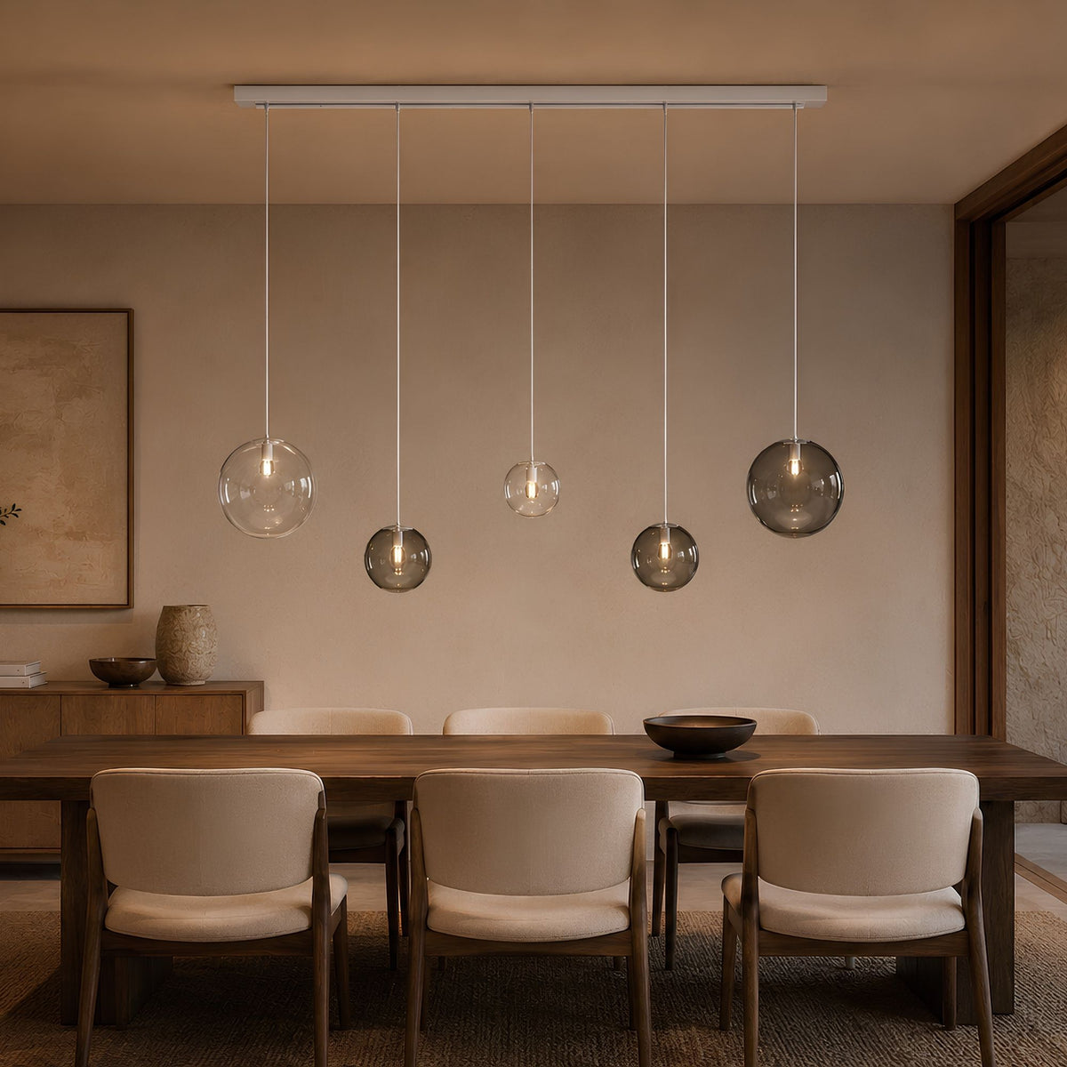 Luminaire présenté de face avec globes transparents et fumés éclairés au-dessus de la table