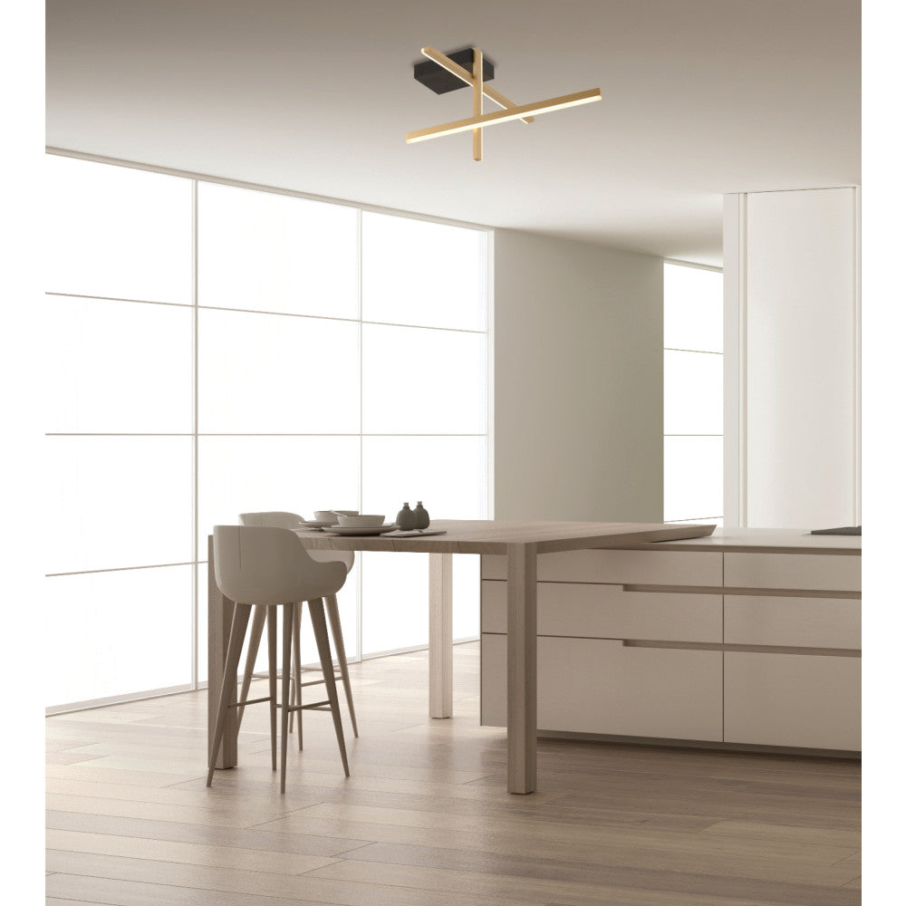 Cuisine équipée avec table haute, tabourets et luminaire doré fixé au plafond.