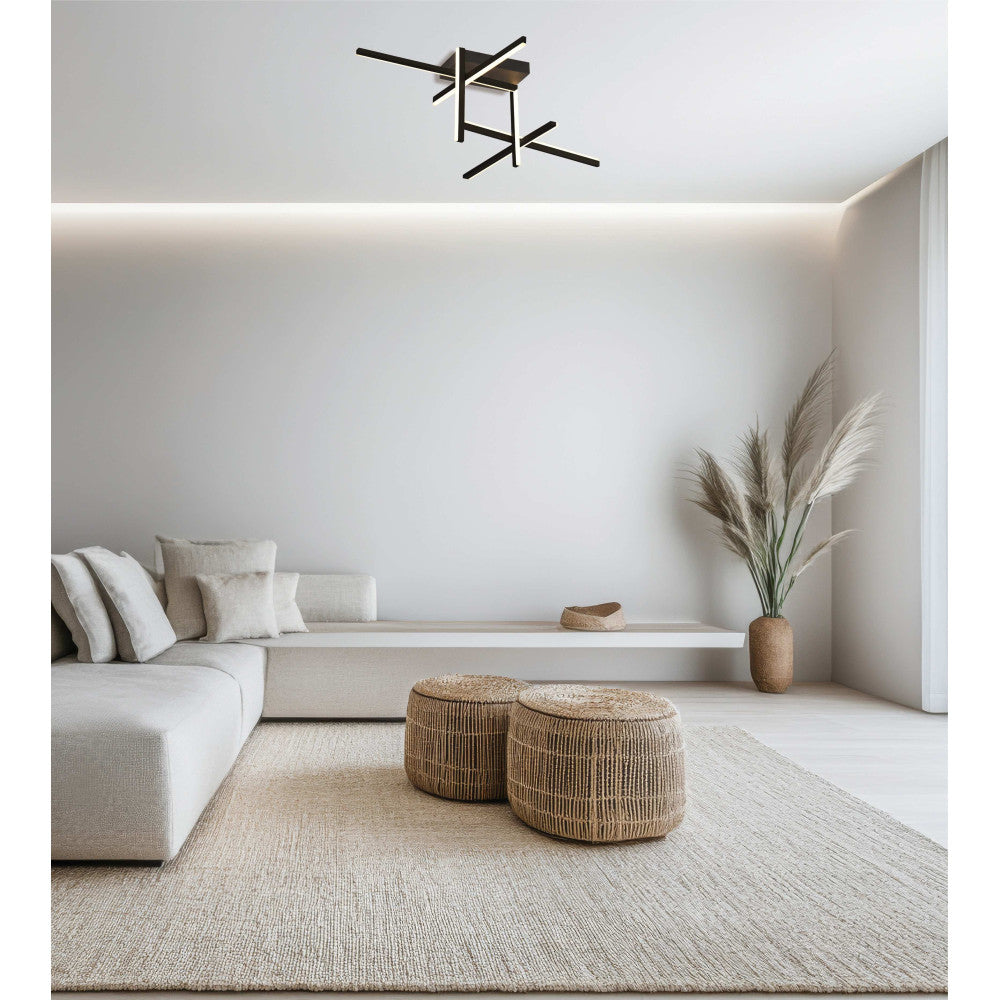 Salon blanc minimaliste avec plafonnier noir au plafond, canapé d'angle et poufs en corde.