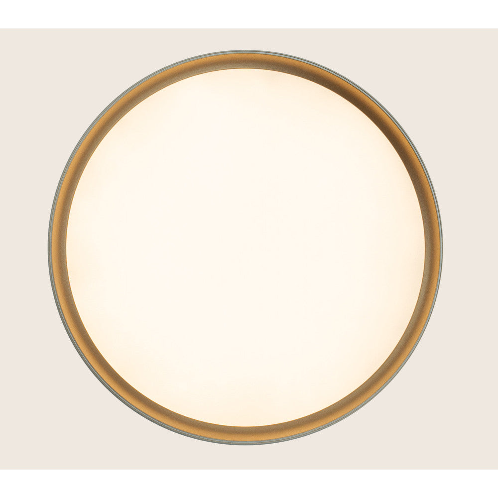 Vue de dessous du luminaire circulaire, large diffuseur blanc bordé d'or.